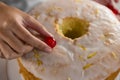 Woman toping a fresh baked cake with cherry