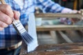 Close Up Of Woman Upcycling Furniture In Workshop At Home Painting Cabinet