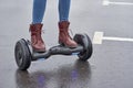 Close up of woman using hoverboard on asphalt road. Feet on electrical scooter outdoor Royalty Free Stock Photo