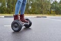 Close up of woman using hoverboard on asphalt road. Feet on electrical scooter outdoor Royalty Free Stock Photo