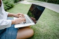 Close-Up of Woman Using Laptop for Business Communication While Sitting on Grass Field. Businesswoman Use Computer Laptop for Royalty Free Stock Photo