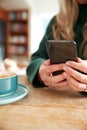 Close Up Of Woman Using Mobile Phone Sitting At Table  In Cafe Royalty Free Stock Photo