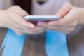 Close up of a woman using mobile smart phone on wooden table Royalty Free Stock Photo