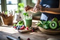 close up woman using a wooden spoon to mix the ingredients of a green smoothie, with spinach, berries, bananas, Generative AI