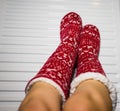 Close-up of a woman warming up her feet on white radiator at home. Central heating concept Royalty Free Stock Photo