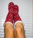 Close-up of a woman warming up her feet on white radiator at home. Central heating concept Royalty Free Stock Photo