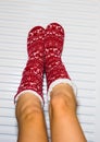 Close-up of a woman warming up her feet on white radiator at home. Central heating concept Royalty Free Stock Photo