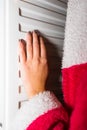 Close-up of a woman warming up her hands on a white radiator at home. Central heating concept Royalty Free Stock Photo