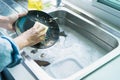 Close-up of a woman washing dishes with dirty food scraps Clean in the sink until the kitchen counter at home Royalty Free Stock Photo