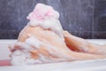 Close up of woman washing knee with pink sponge in bathtub Royalty Free Stock Photo