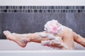 Close up of woman washing leg with sponge in bathtub Royalty Free Stock Photo