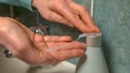 CLOSE UP: Woman washing pours liquid soap into her palm to disinfect her hands Royalty Free Stock Photo