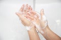 Close up a woman is washing soap foam from her hands under running water Royalty Free Stock Photo