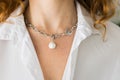 Close-up woman wearing beautiful luxury necklace with pearl pendant. Handmade jewellery and accessory Royalty Free Stock Photo