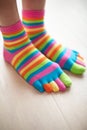 Close Up Of Woman Wearing Brightly Colored Socks On Feet Standing On Wooden Floor