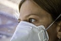 Close up woman wearing a FFP3 face mask looking outside. Disposable respirator protective mouth filter mask Royalty Free Stock Photo