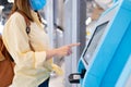 Woman wearing mask self-check in for the flight in airport. concept of new normal travel