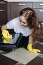 Woman, wearing in protective glove with rag cleaning oven at kitchen. Royalty Free Stock Photo