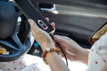 Close up a woman in a white dress charging her mobile phone with car charger cable Royalty Free Stock Photo