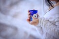 Close up of woman in white sweater in hands holding blue cup of coffee near window at home with winter outdoors in the background Royalty Free Stock Photo