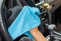 Close up of woman wiping car interior with blue rag