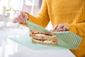 Close Up Of Woman Wrapping Sandwich In Reusable Environmentally Friendly Beeswax Wrap