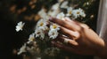 Close-up of a woman& x27;s hand holding a daisy, blurred greenery Royalty Free Stock Photo