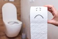 Funny face drawn on a roll of toilet paper on the background of the bathroom Royalty Free Stock Photo