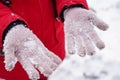 Close up of woman's hands in gloves with snow. Unrecognizable woman playing with snow on walk in wintertime.