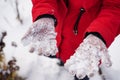 Close up of woman's hands in gloves with snow. Unrecognizable woman playing with snow on walk in wintertime.