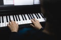 Rear view of woman& x27;s hands playing piano by reading sheet music. Selective focus Royalty Free Stock Photo