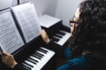 Close up of woman& x27;s hands playing piano by reading sheet music. Selective focus Royalty Free Stock Photo