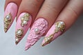 A close up of a woman& x27;s pink nails with gold accents, AI