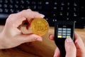 Close up womans hand holding bitcoin and cryptocurrencey hardware cold wallet on keybord background. Secure