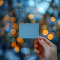 Close up Womans hand holding small blue paper with bokeh backdrop