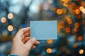 Close up Womans hand holding small blue paper with bokeh backdrop