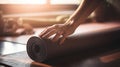 Close up of a womans hands is rolling up exercise mat and preparing to doing yoga. She is exercising on floor mat in morning