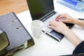 Close up of womans hands typing on laptop with folders and mug Royalty Free Stock Photo