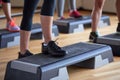 Close up of women exercising with steppers in gym