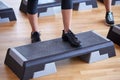 Close up of women exercising with steppers in gym