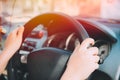 Close up women hand driving city car