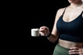 Close up of women hand holding measuring scoop of whey protein preparing protein shake