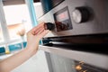 Close up of women hand setting cooking mode on oven Royalty Free Stock Photo