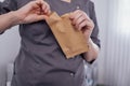 Close-up of women hands with a neat manicure opening a paper bag