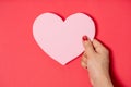 Close up women holding pink blank paper with heart shape on white background