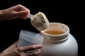 Close up of women with measuring scoop of whey protein, jar and shaker bottle, preparing protein shake