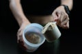 Close up of women with measuring scoop of whey protein and shaker bottle, preparing protein shake
