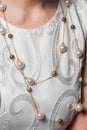 Close-up women's beads with pearls costume jewelry around the neck white jewelry