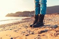 Close-up of women`s feet in black casual shoes, standing on the sand of the beach, autumn or winter. Copy space Royalty Free Stock Photo