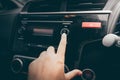 Close-up Of Women`s Hand Turning Button Of Radio In Car.